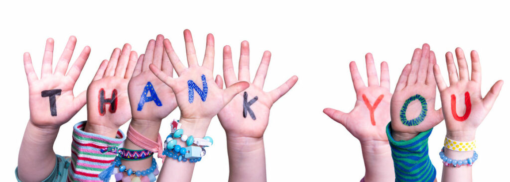 Vielen Dank Nach oben gestreckte Kinderhände. Auf den Händen steht ``Thank You``